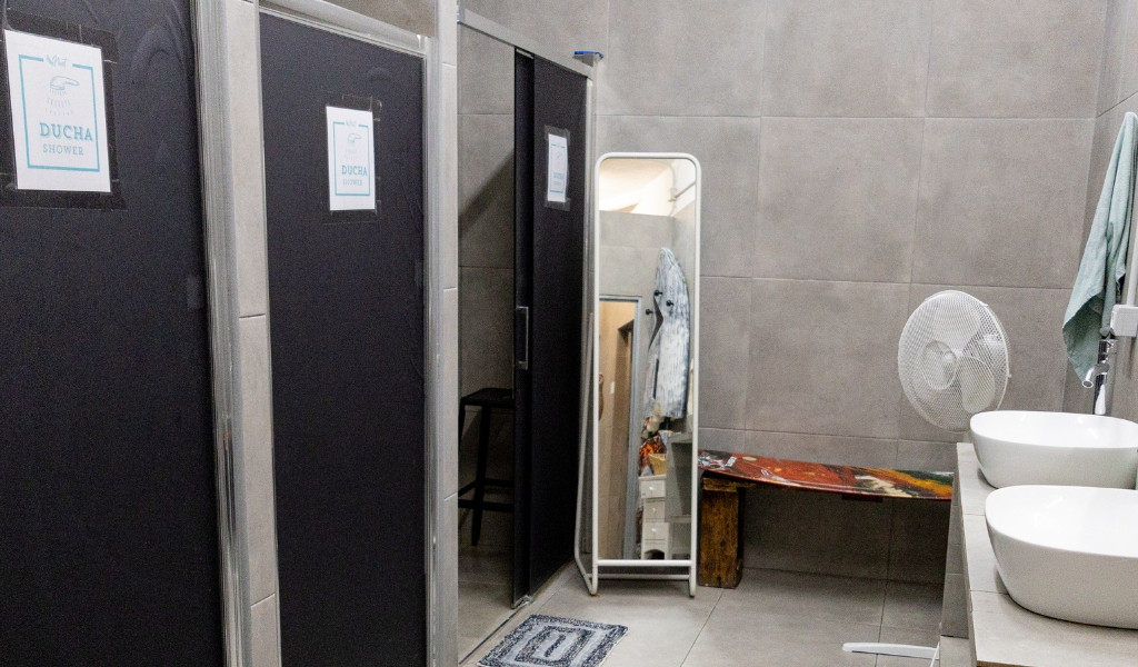 Duschkabinen und Spiegel in Badezimmer von Tenerife Hostel.