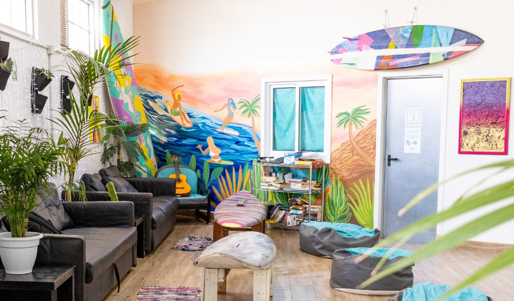 Lounge mit Sofas, Pflanzen und Surfbrett-Wanddekoration in Puerto de la Cruz, Teneriffa.