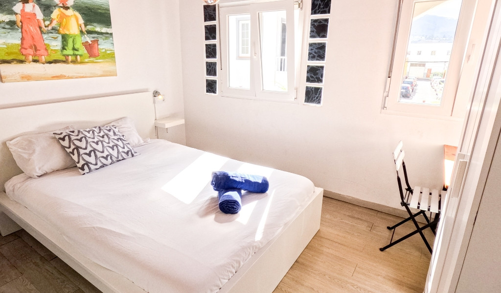 Schlafzimmer mit Bett, Fenster und Stuhl, Playa de las Américas, Teneriffa.