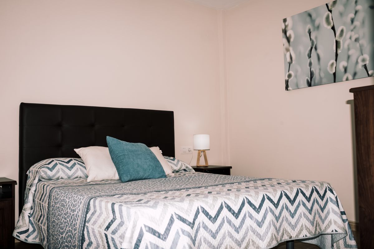 Schlafzimmer mit Doppelbett, Nachttischlampe und Kissen in Teneriffa.