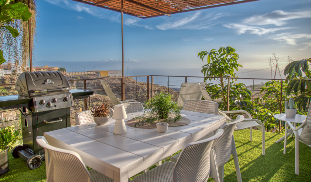 Terrasse mit Tisch, Stühlen, Grill und Blick auf das Meer in Teneriffa.