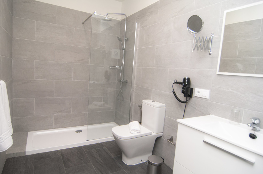 Moderne Badezimmer mit Dusche, WC, Spiegel und Haartrockner in einem Hotel in Tenerife.