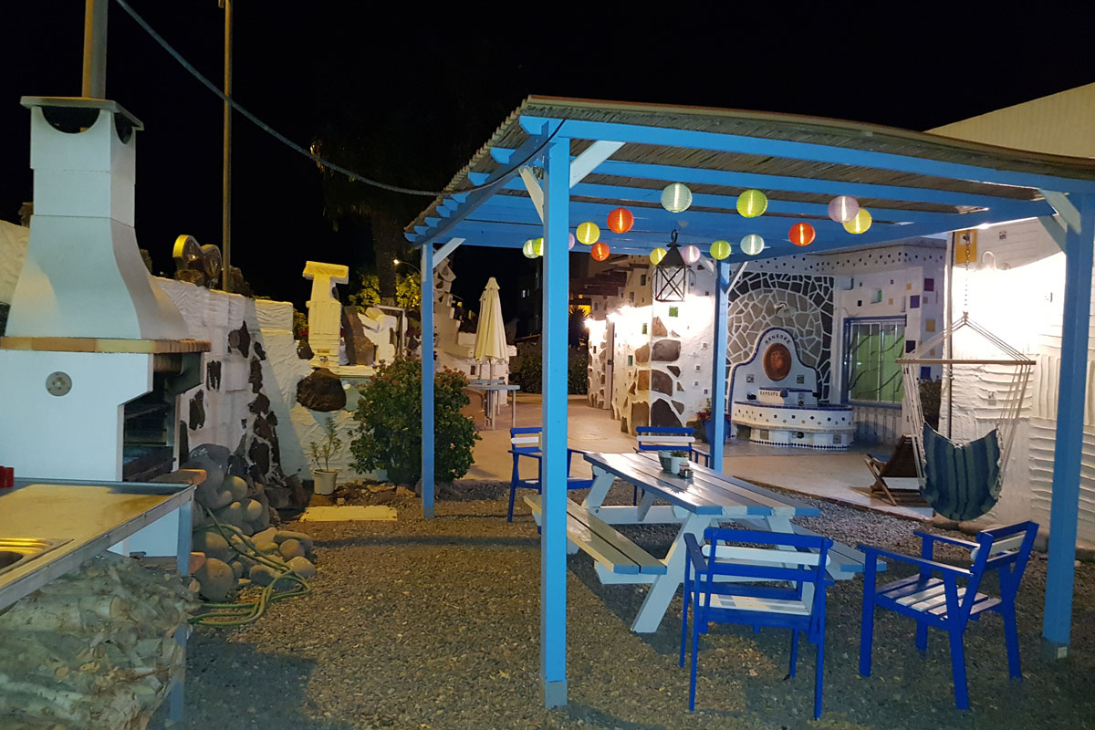 Überdachter Sitzbereich mit Grill und bunten Laternen in einem Innenhof in Tenerife.