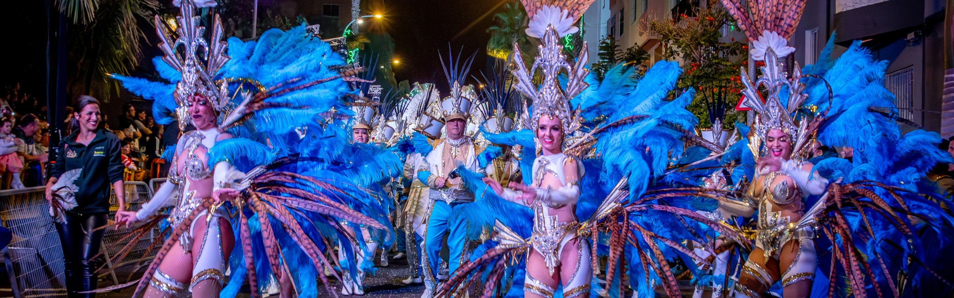 Menschen in bunten Kostümen und Federn beim Karneval von Santa Cruz de Tenerife.