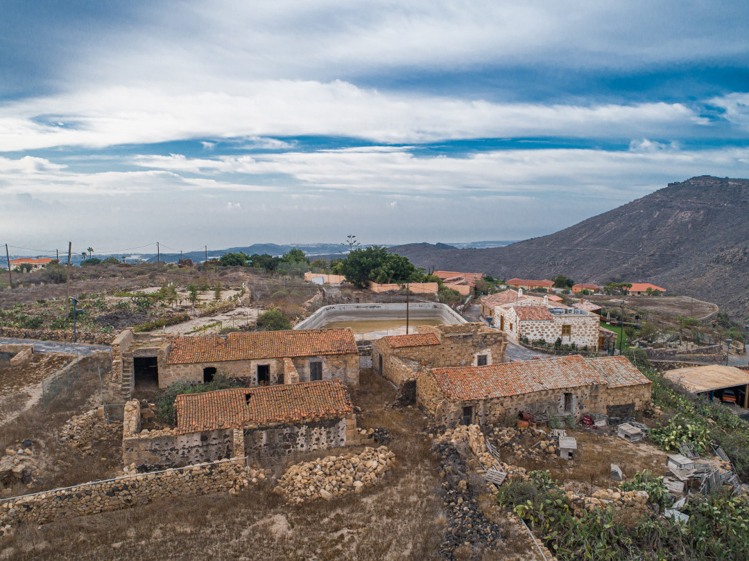 Ruinen alter Steinhäuser mit Ziegeldächern auf Teneriffa, umgeben von ländlicher Natur.
