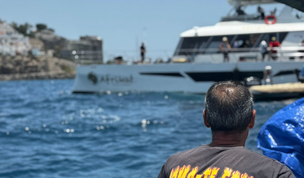 Person, die ein Ausflugsboot auf See in Los Gigantes, Teneriffa, betrachtet.