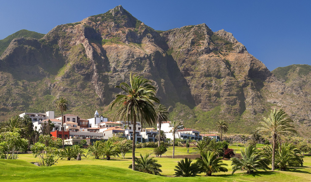 Bergige Landschaft mit Palmen und Gebäuden in Buenavista del Norte, Teneriffa.