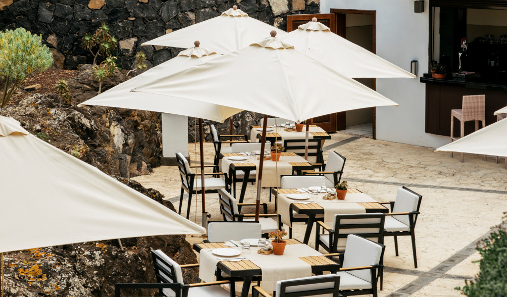 Terrasse mit Tischen und Sonnenschirmen in einem Open-Air-Restaurant auf Teneriffa.