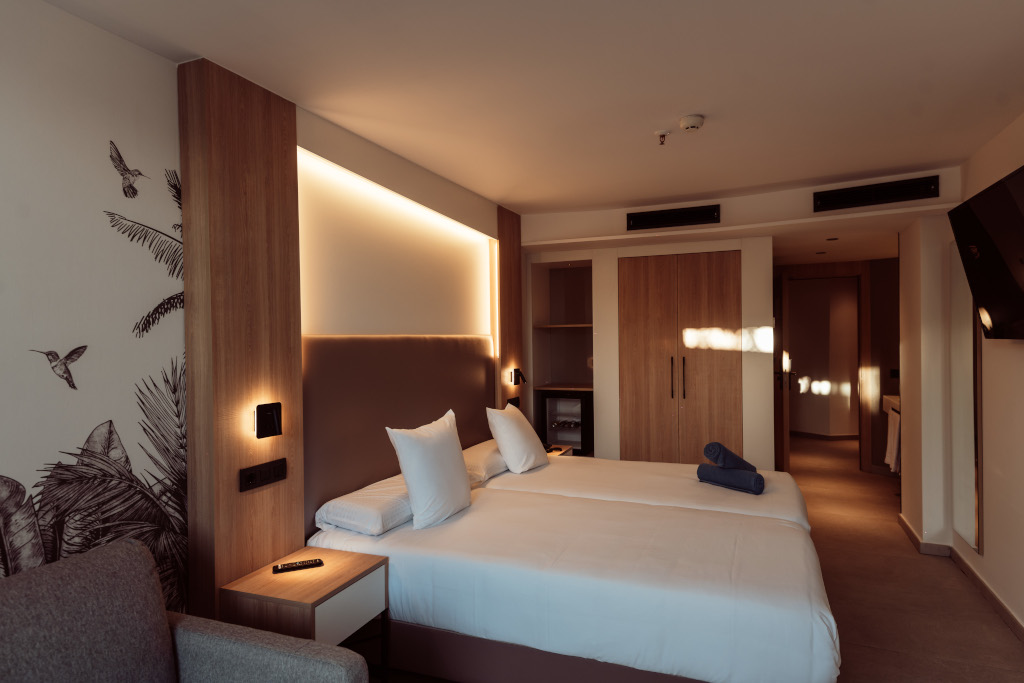 Hotelzimmer auf Teneriffa mit Doppelbett, sanfter Beleuchtung und eingebautem Kleiderschrank.