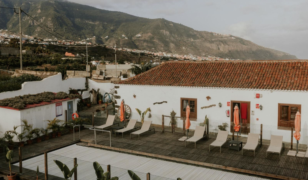 Stühle und Sonnenschirme auf einer Terrasse mit Berg im Hintergrund auf Teneriffa.