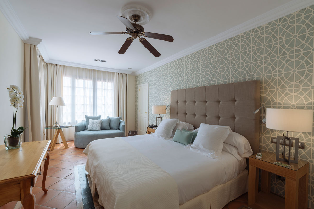 Helles Zimmer mit Doppelbett und Sofa in einem Hotel auf Teneriffa.