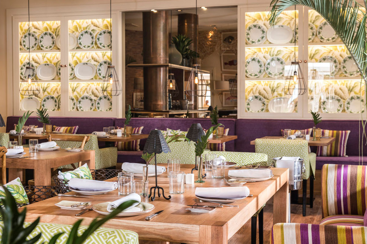 Restaurant auf Teneriffa mit vorbereiteten Tischen und Blumendekor an den Wänden.