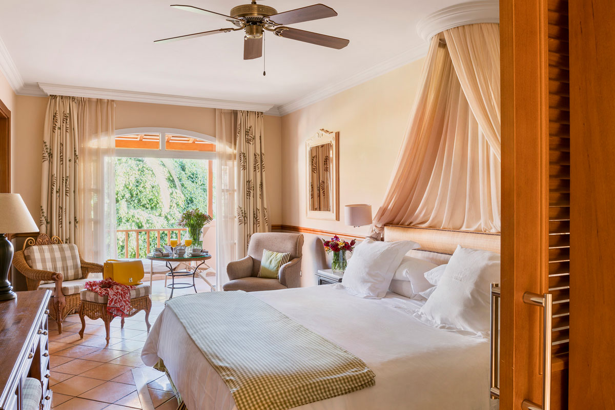 Zimmer mit großem Bett, eleganten Möbeln und Blick auf den Garten auf Teneriffa.