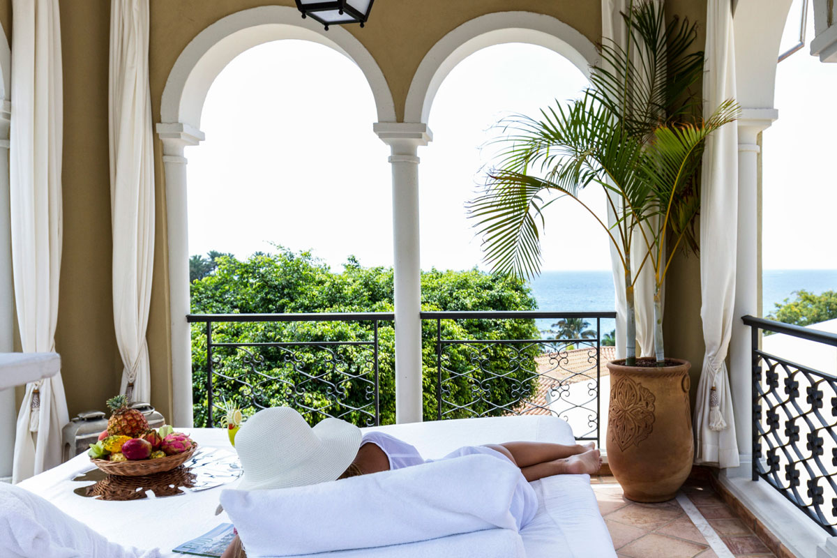 Person, die auf einer Terrasse mit Meerblick auf Teneriffa entspannt.