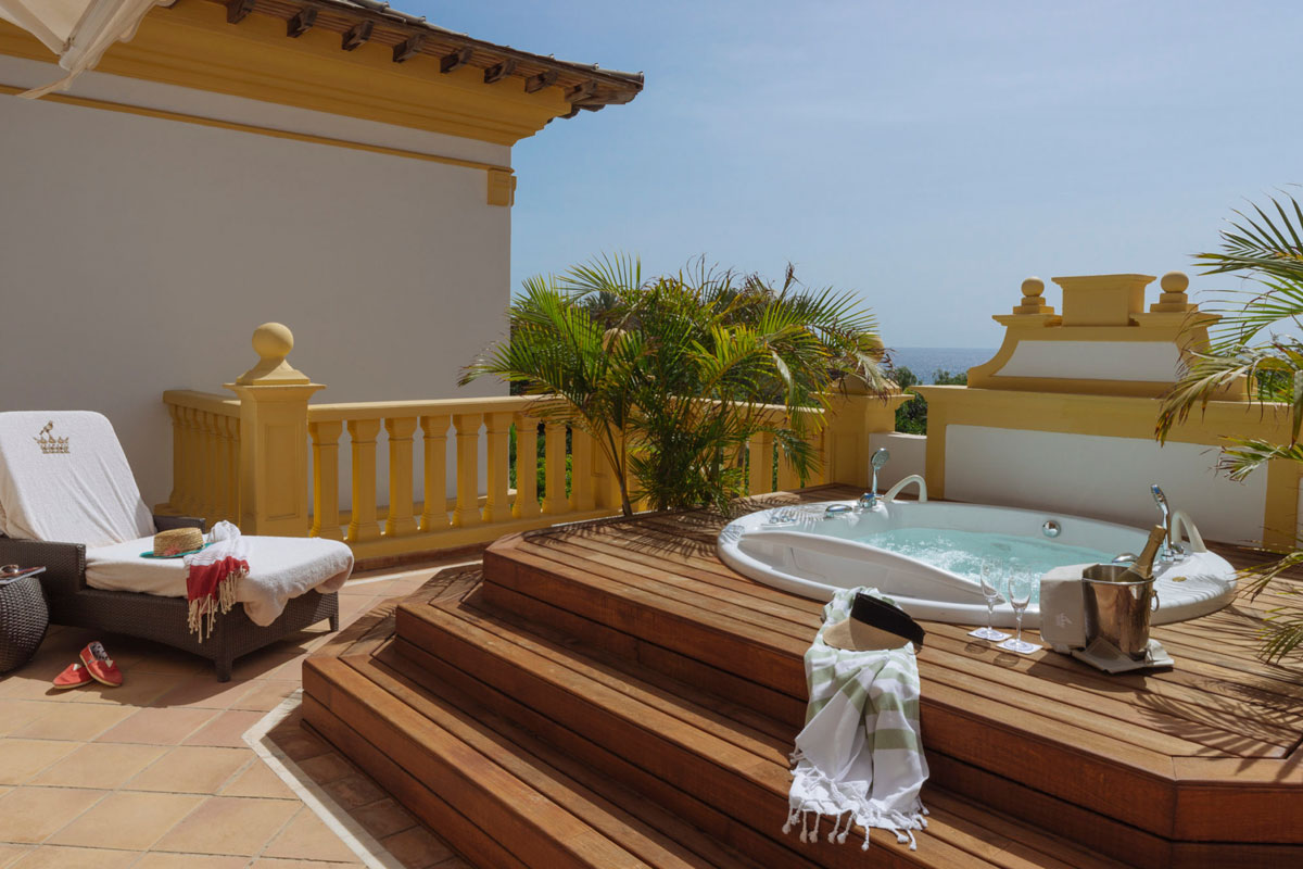 Terrasse mit Jacuzzi, Sonnenliege und Meeresblick in einem Hotel auf Teneriffa.
