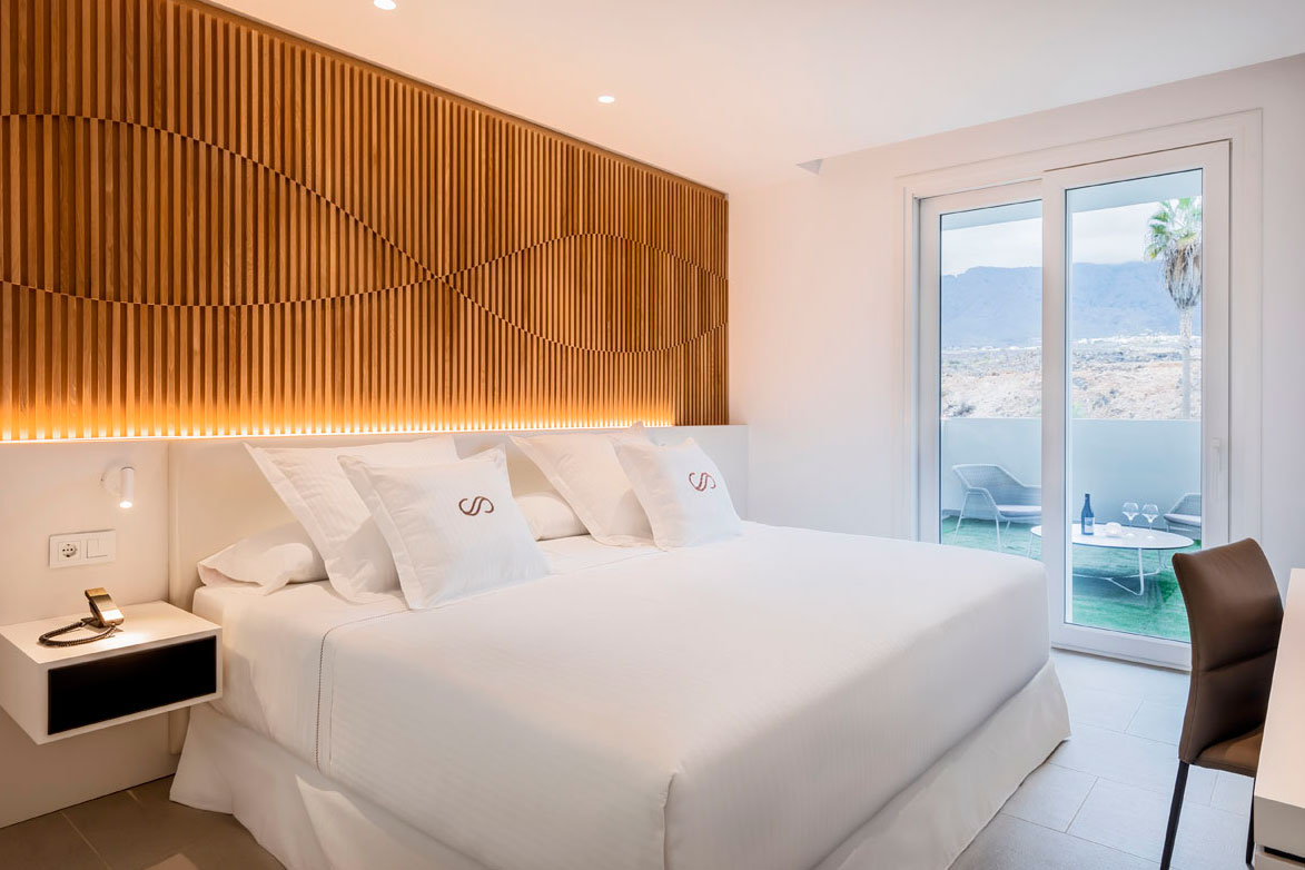 Hotelzimmer auf Teneriffa mit Doppelbett, Terrasse und Außenansicht.