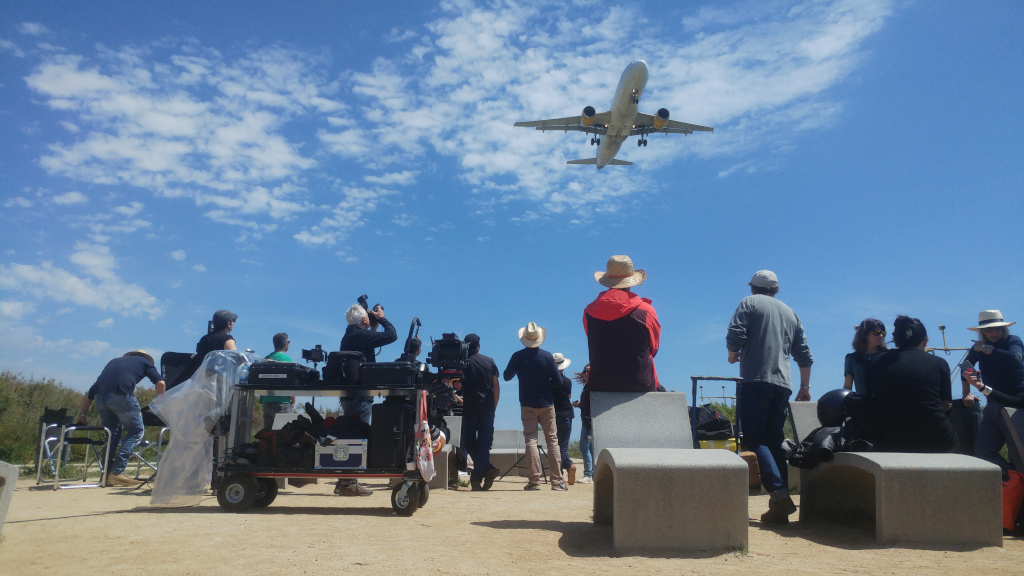 Eine Gruppe von Menschen beobachtet, wie ein Flugzeug tief auf Teneriffa fliegt.