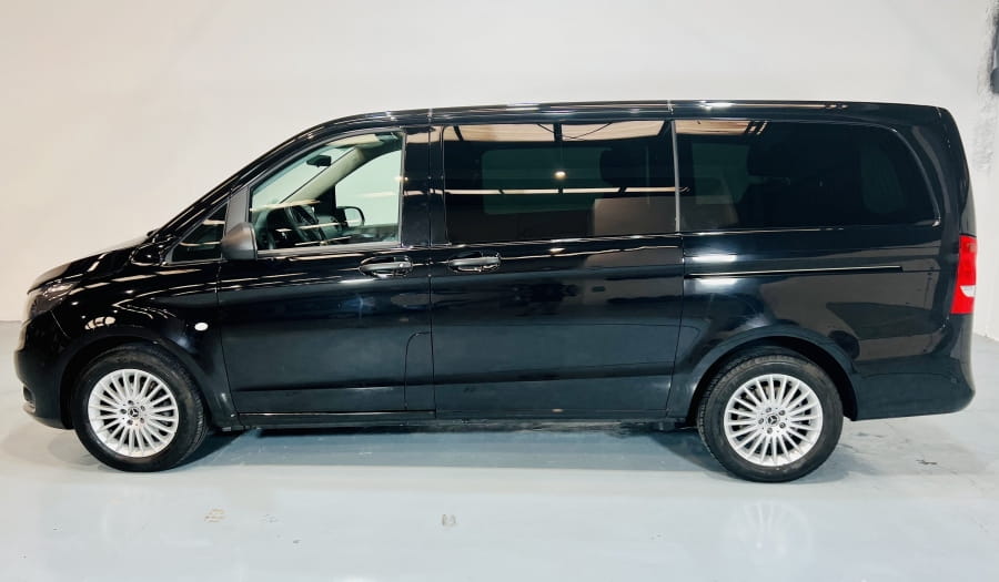Schwarzer Minivan im Profil in einem Studio auf Teneriffa geparkt.