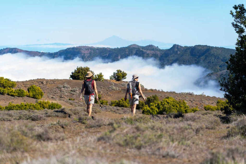 Zwei Wanderer im Teide Nationalpark auf Teneriffa mit Wolken im Hintergrund.