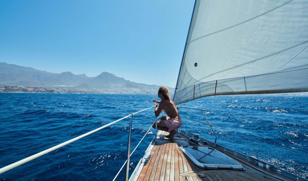 Person segelt vor der Küste von Tenerife mit Aussicht auf das Meer und die Berge.