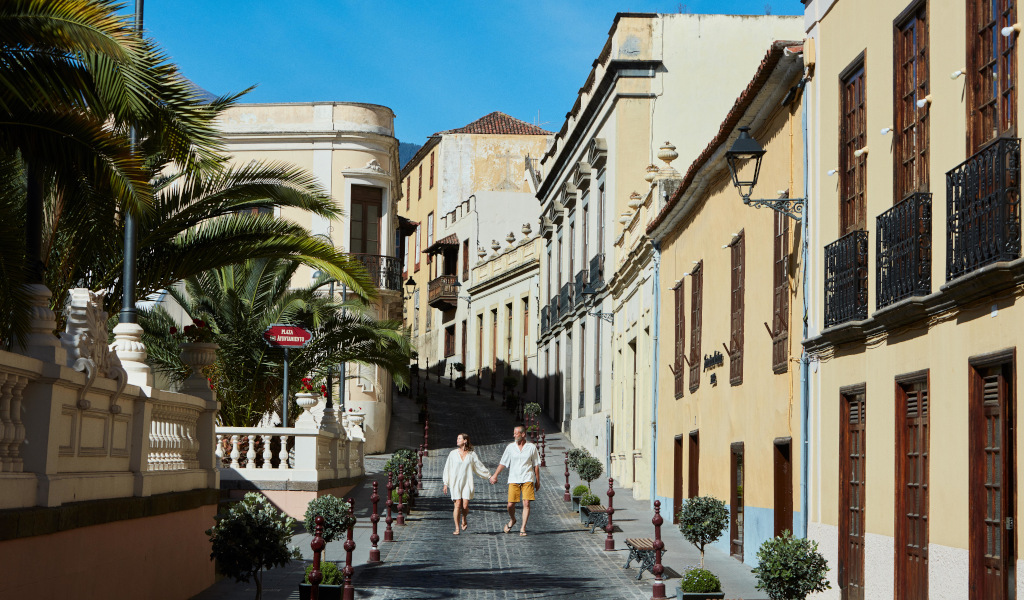 Paar auf Straße in La Orotava, Teneriffa, umgeben von historischen Gebäuden.