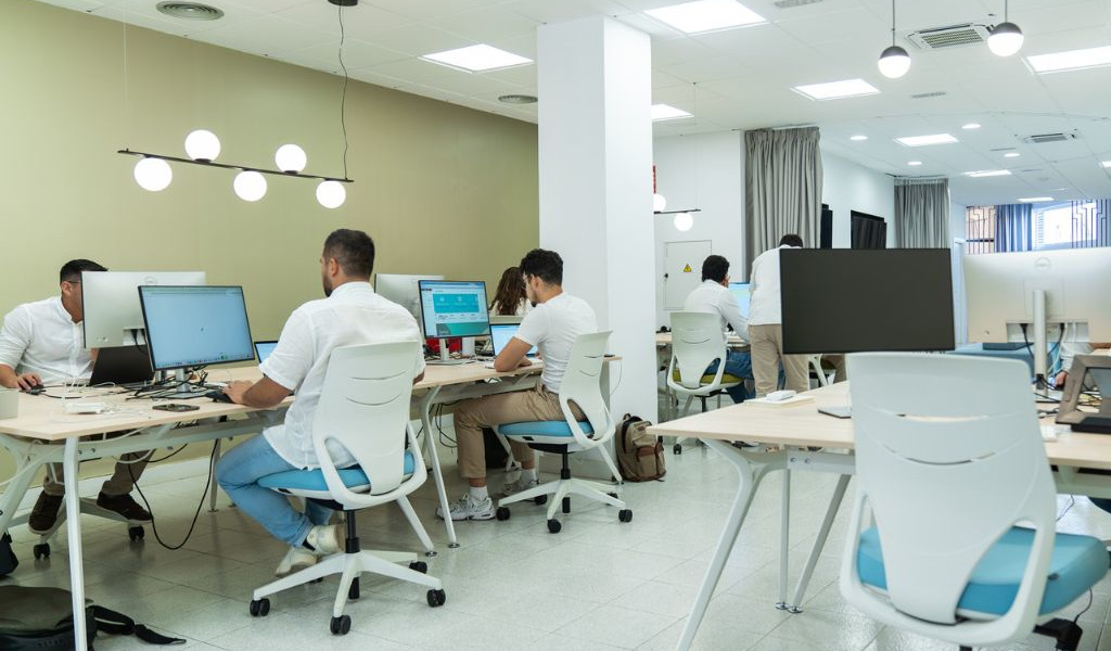 Menschen arbeiten in einem modernen Büro in Santa Cruz de Tenerife an Computern.
