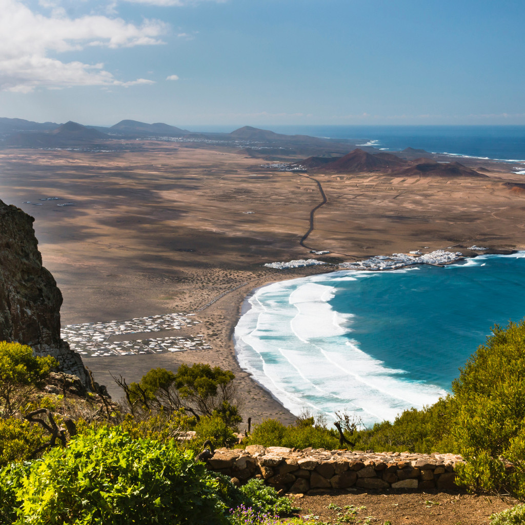 Panoramablick auf die Küste mit Wellen, die an einem Sandstrand auf Teneriffa brechen.