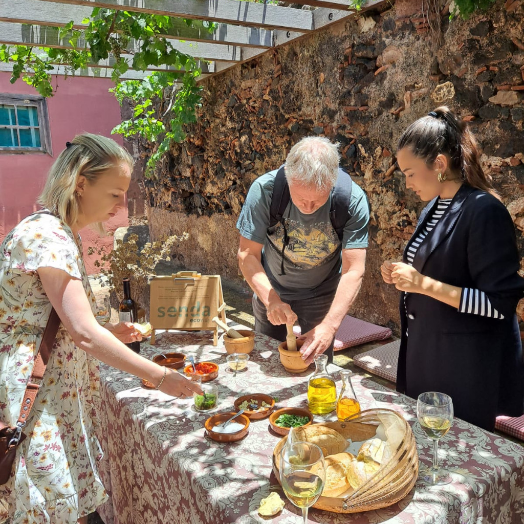Menschen bereiten Essen an einem Tisch im Freien in La Laguna, Teneriffa, zu.