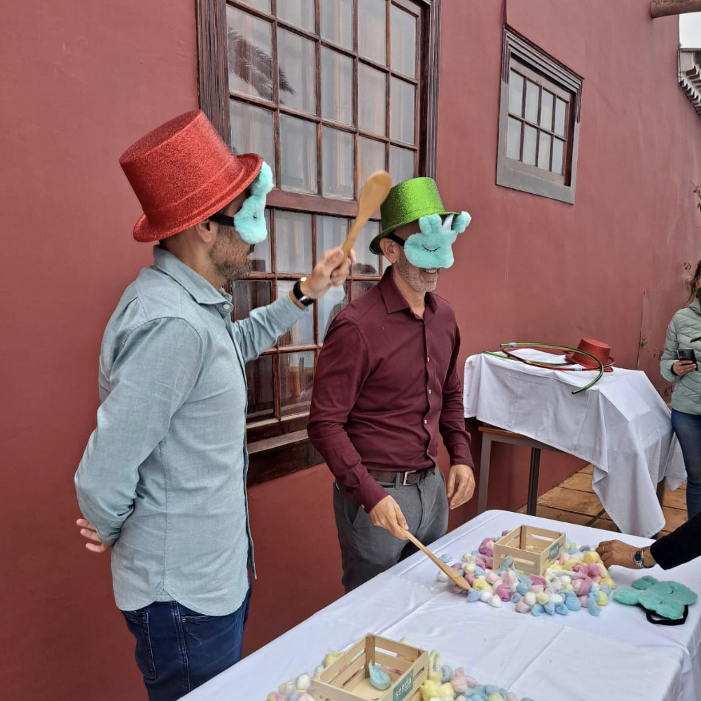 Menschen mit Hüten spielen auf Teneriffa mit Löffeln und bunten Gegenständen.