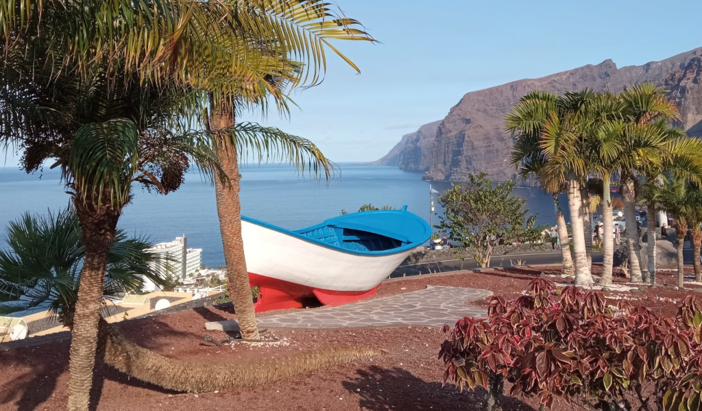Blau-weißes Boot in einem Park mit Blick auf Los Gigantes, Teneriffa.