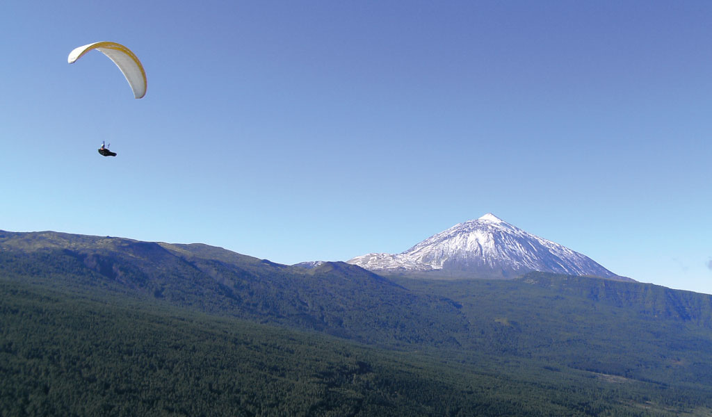 Gleitschirmfliegen über den Teide auf Teneriffa bei klarem Himmel.
