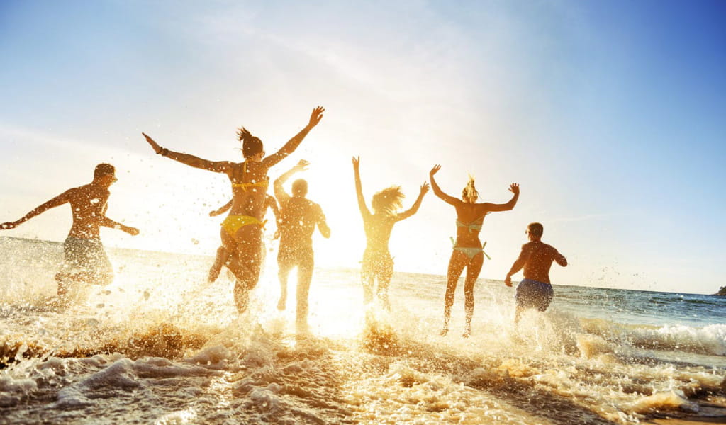 Menschen, die am Meeresufer an einem Strand auf Teneriffa rennen.