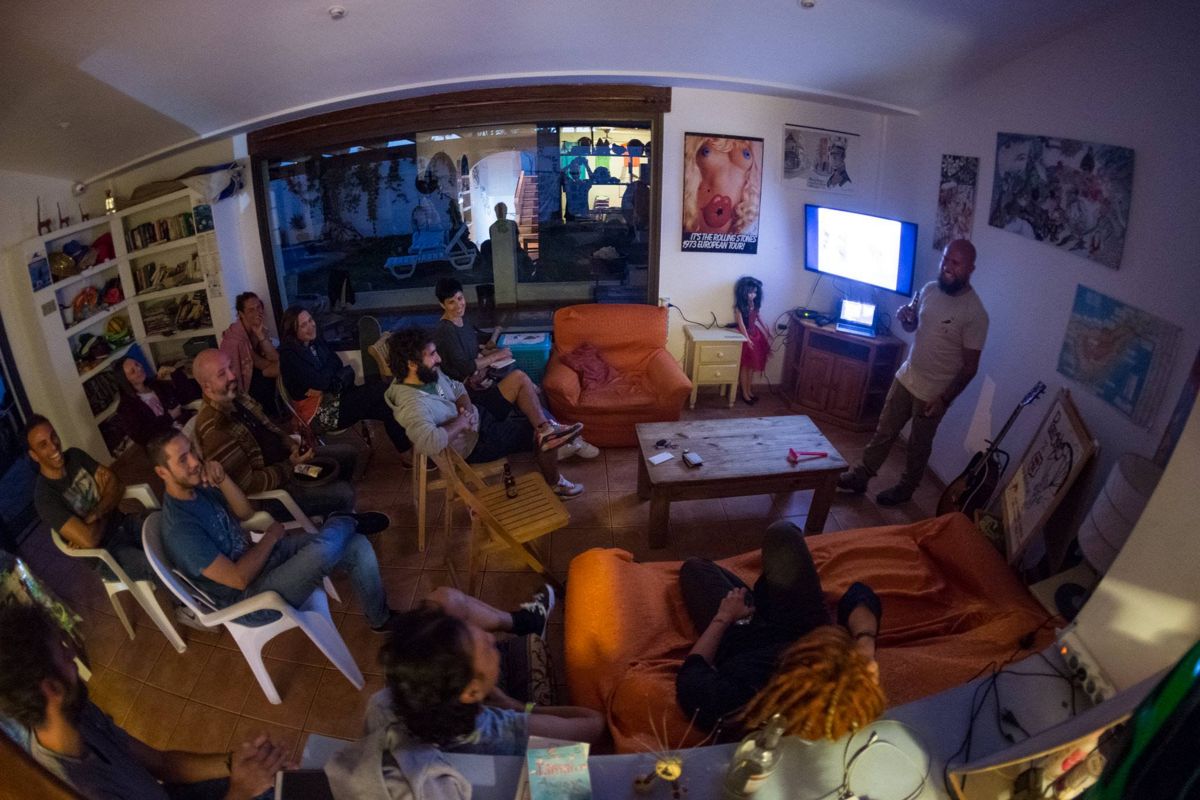 Eine Gruppe von Menschen, die an einer Präsentation in einem Wohnzimmer auf Teneriffa teilnehmen.