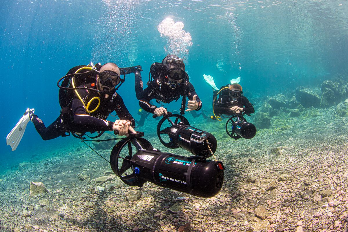 Taucher mit Unterwassertriebwerken erkunden kristallklares Wasser auf Teneriffa.