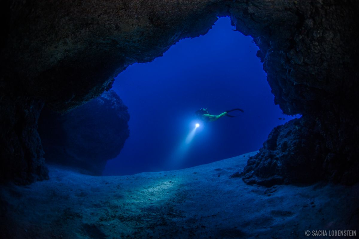 Unterwasser-Höhlentaucher, der den Meeresboden auf Teneriffa beleuchtet.