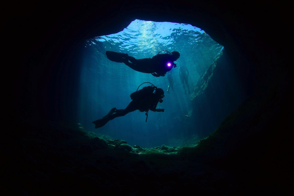 Taucher, die eine Unterwasserhöhle auf Teneriffa erkunden.