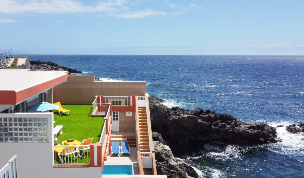 Terrasse mit Rasen und Sonnenliegen am Meer auf einer Klippe auf Teneriffa.