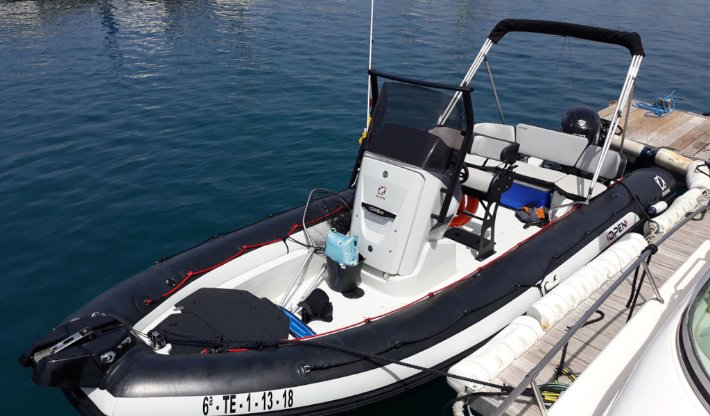 Ein Schlauchboot lag im Hafen von Teneriffa, mit sichtbaren Sitzen und Motor.