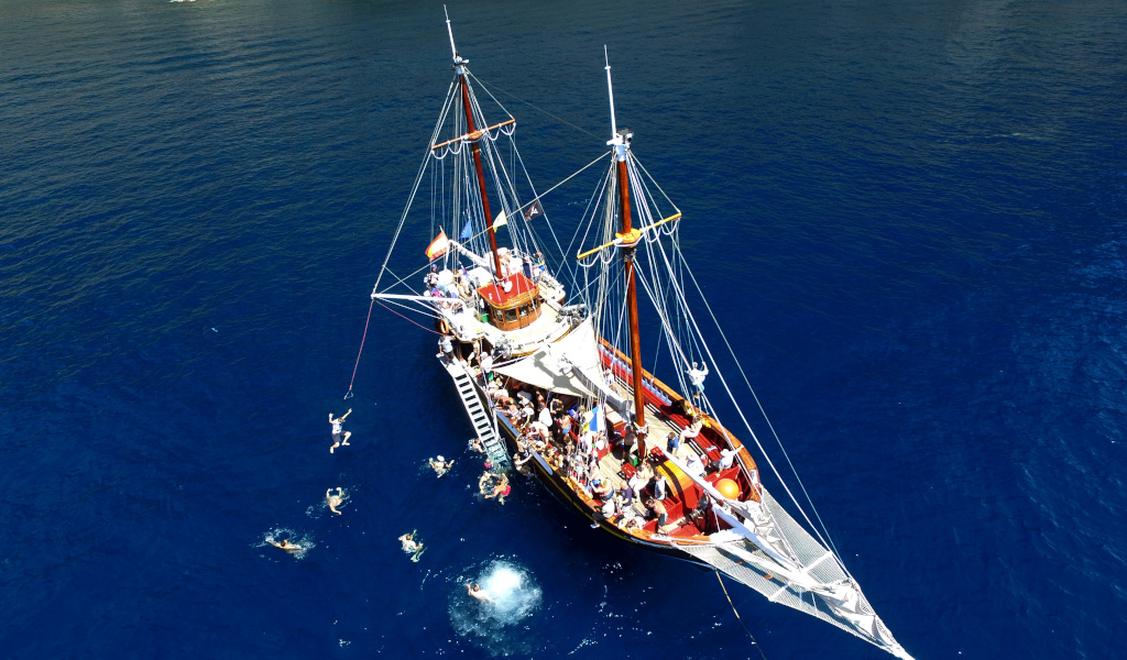 Touristenboot mit schwimmenden Personen in der Nähe von Teneriffa.