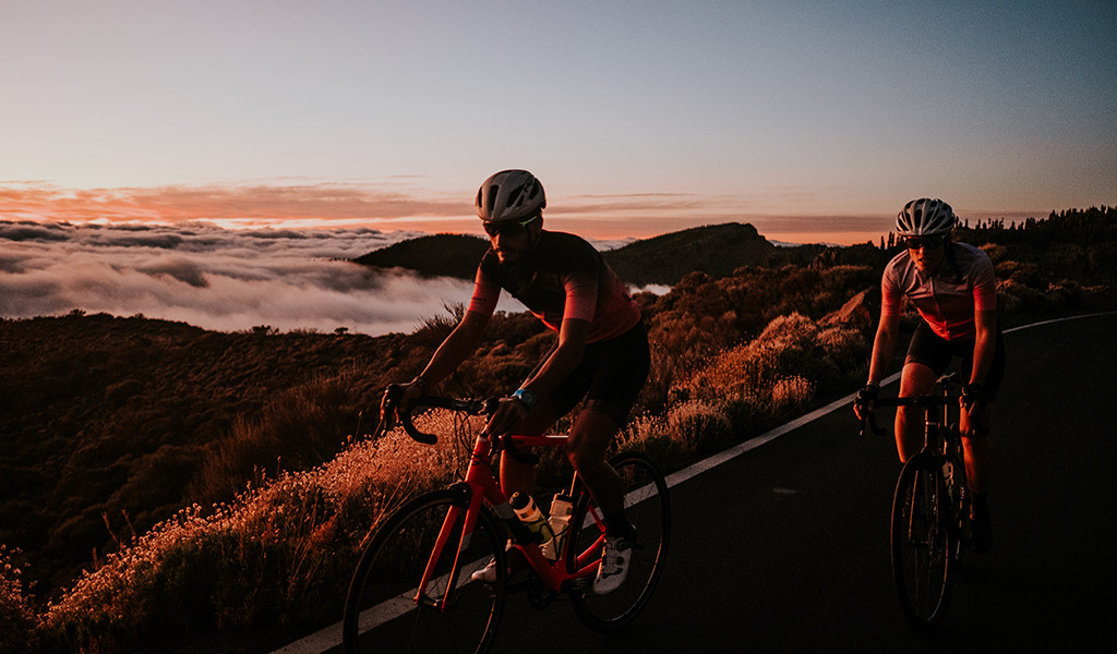 Straßenradfahrer mit bergiger Landschaft bei Sonnenuntergang auf Teneriffa.