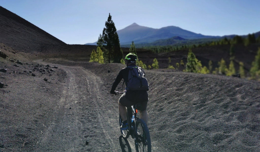Radfahrer auf einem Vulkanweg mit dem Teide im Hintergrund auf Teneriffa.