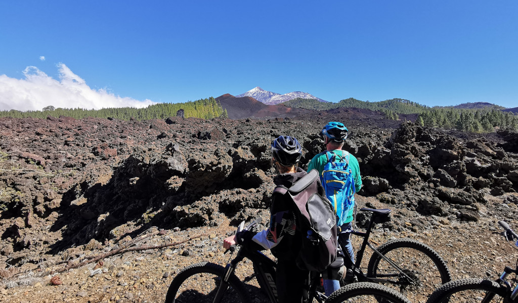 Zwei Radfahrer betrachten die vulkanische Landschaft nahe dem Teide auf Teneriffa.