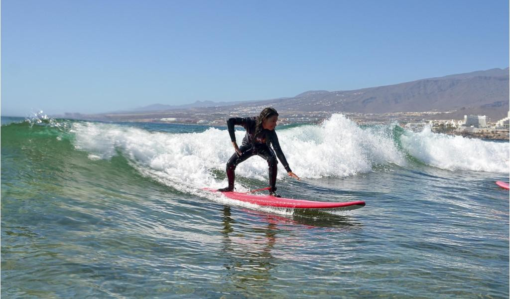 Person, die auf einer Welle in Playa de Las Americas, Teneriffa, surft.