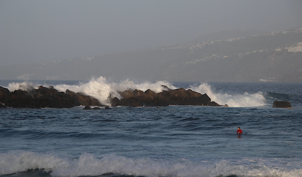 Wellen, die gegen Felsen im Meer in Puerto de la Cruz, Teneriffa, schlagen.