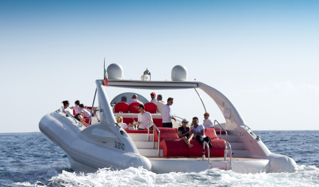 Menschen, die eine Fahrt auf einem Boot mit roten Sitzen im Meer nahe Teneriffa genießen.
