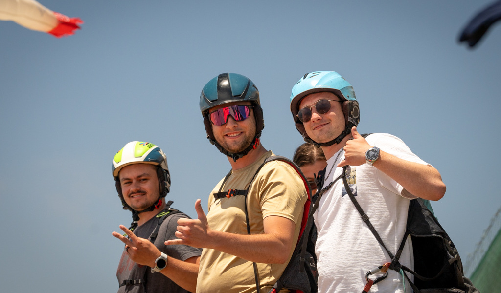 Drei Personen mit Helmen lächeln und zeigen an einem sonnigen Tag auf Teneriffa einen Daumen hoch.