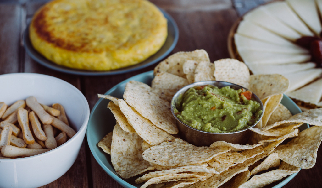 Nachos mit Guacamole, Brotstangen, Tortilla und Käse auf einem Tisch auf Teneriffa.