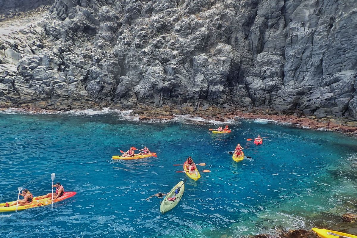 Kajaks im kristallklaren Wasser neben Klippen auf Teneriffa.