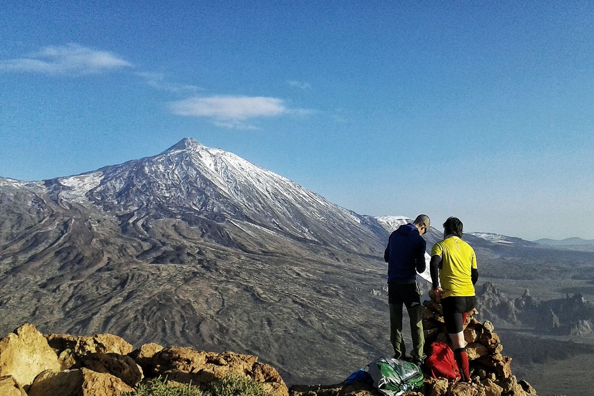 Zwei Personen stehen an einem Aussichtspunkt mit Blick auf den Vulkan Teide auf Teneriffa.