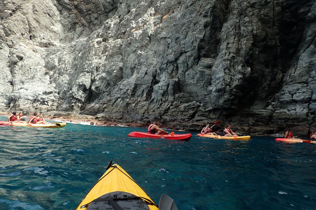 Menschen, die an den Klippen entlang der Küste Teneriffas Kajak fahren.